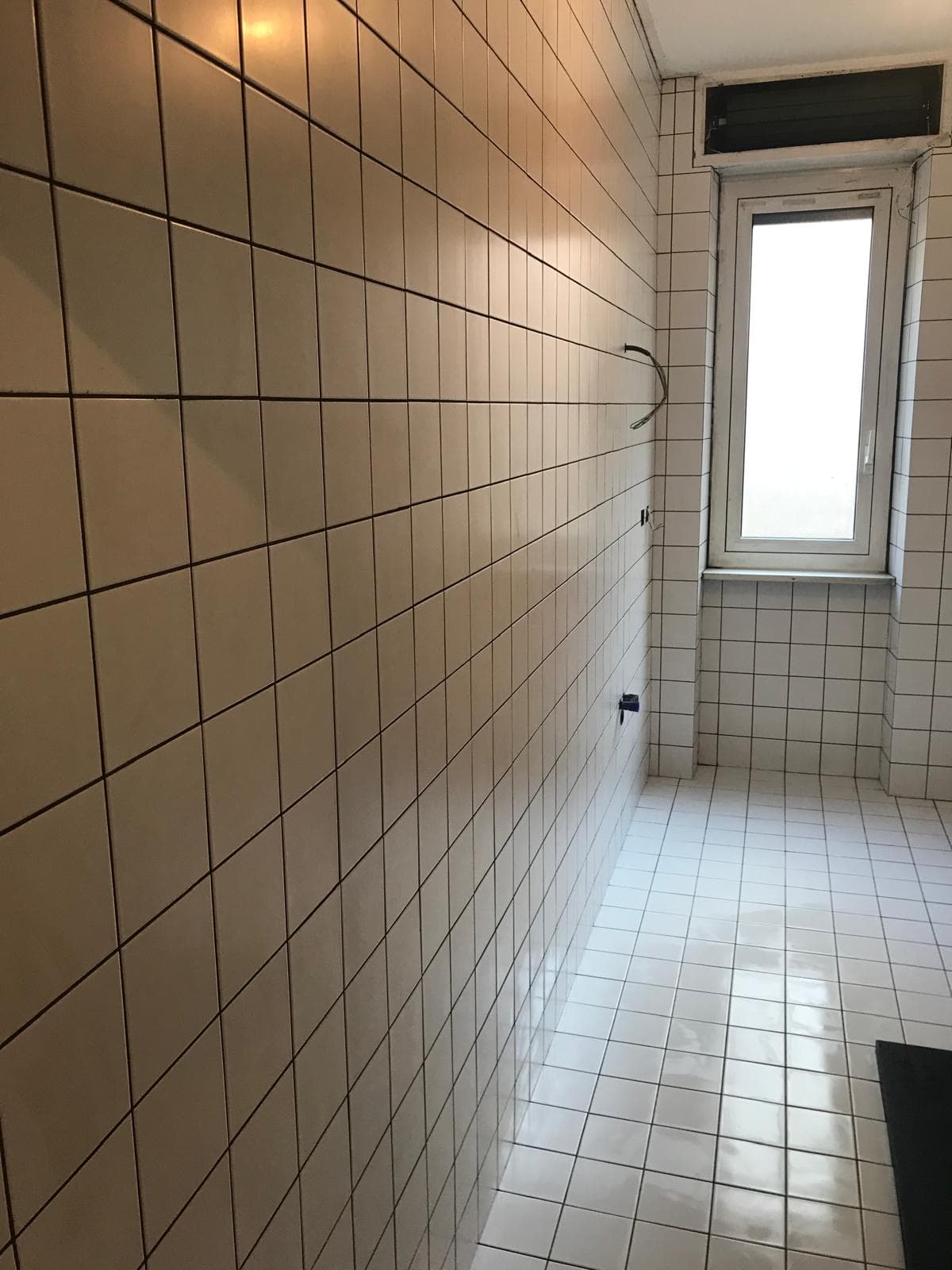 Corridoio del bagno con piastrelle e finestra